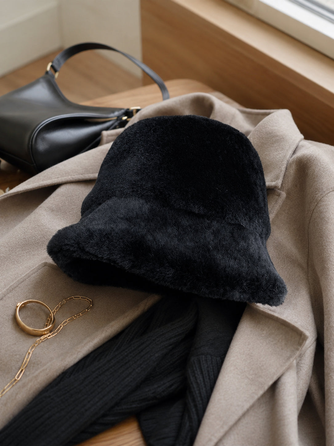Black short-brim bucket hat styled with monochrome layers
