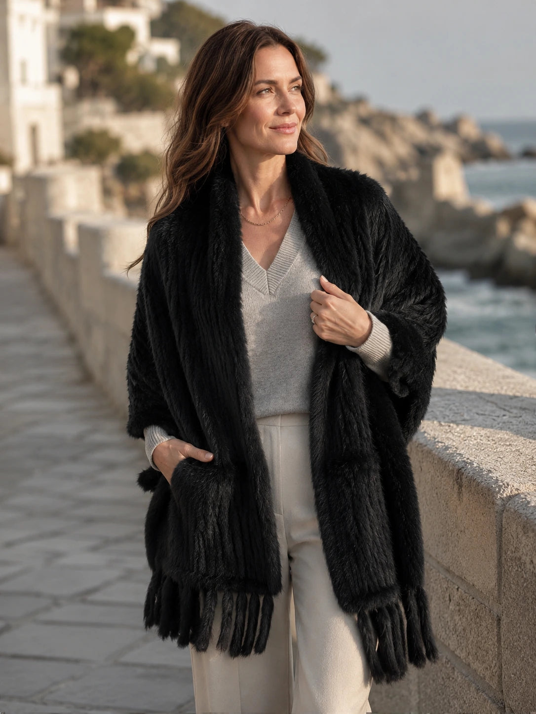 Woman wearing a black rabbit fur pocket shawl near the coast