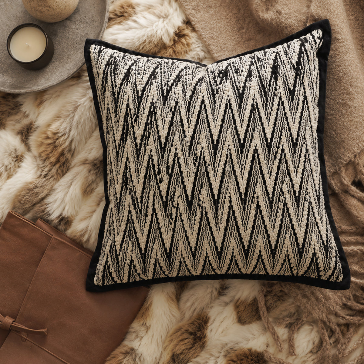 Black and white herringbone cushion styled flat lay