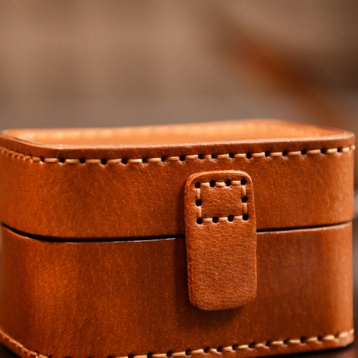 Close-up of the stitched leather tab closure