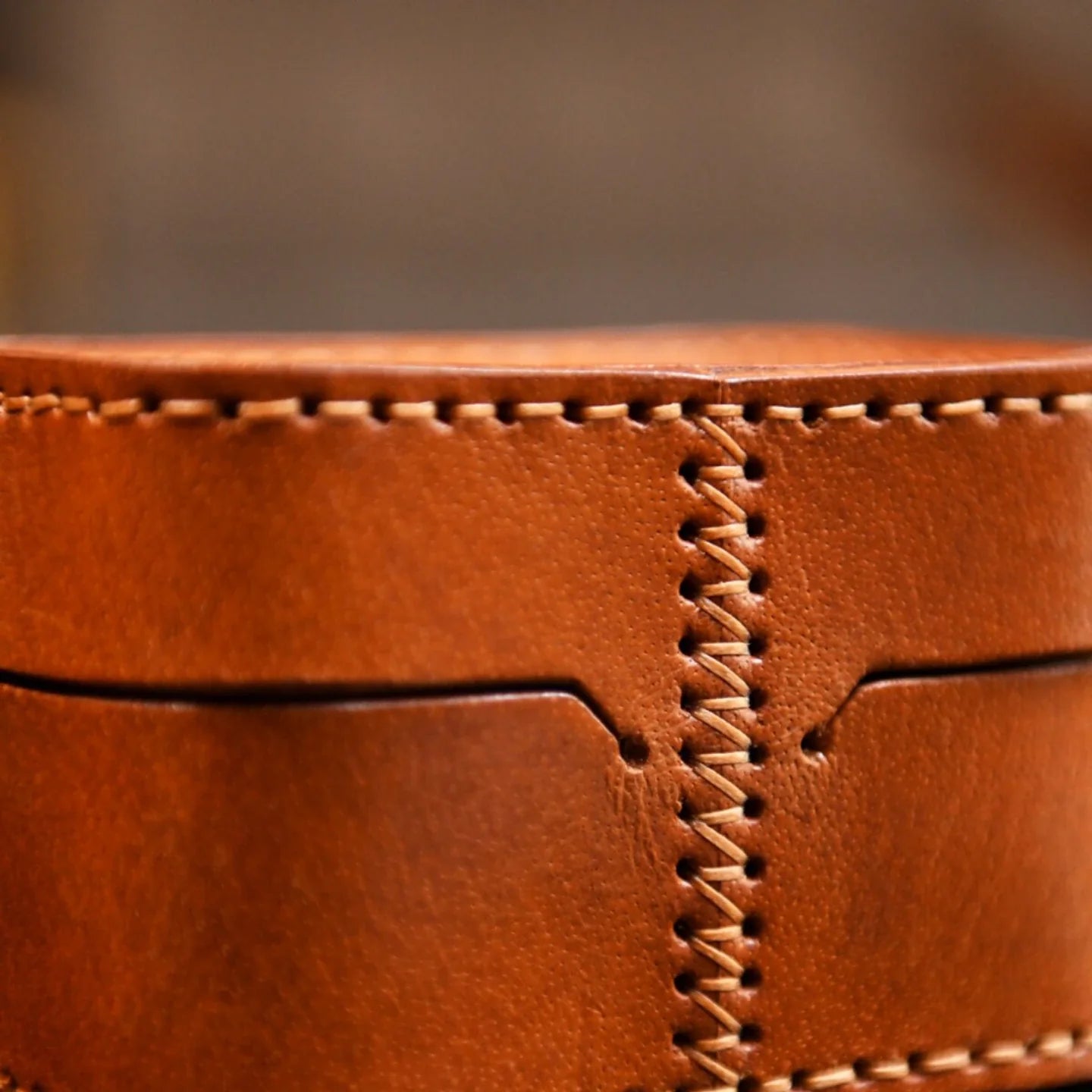 Close-up of hand stitching and cowhide grain