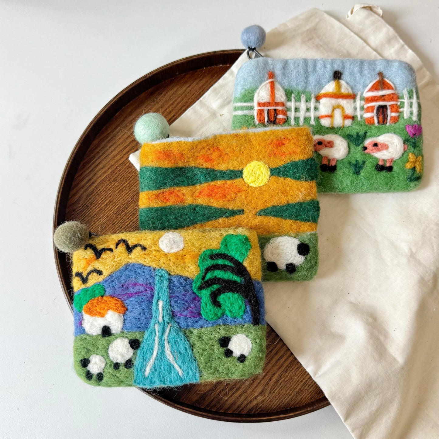 Handmade felt sheep pouches in a natural setting