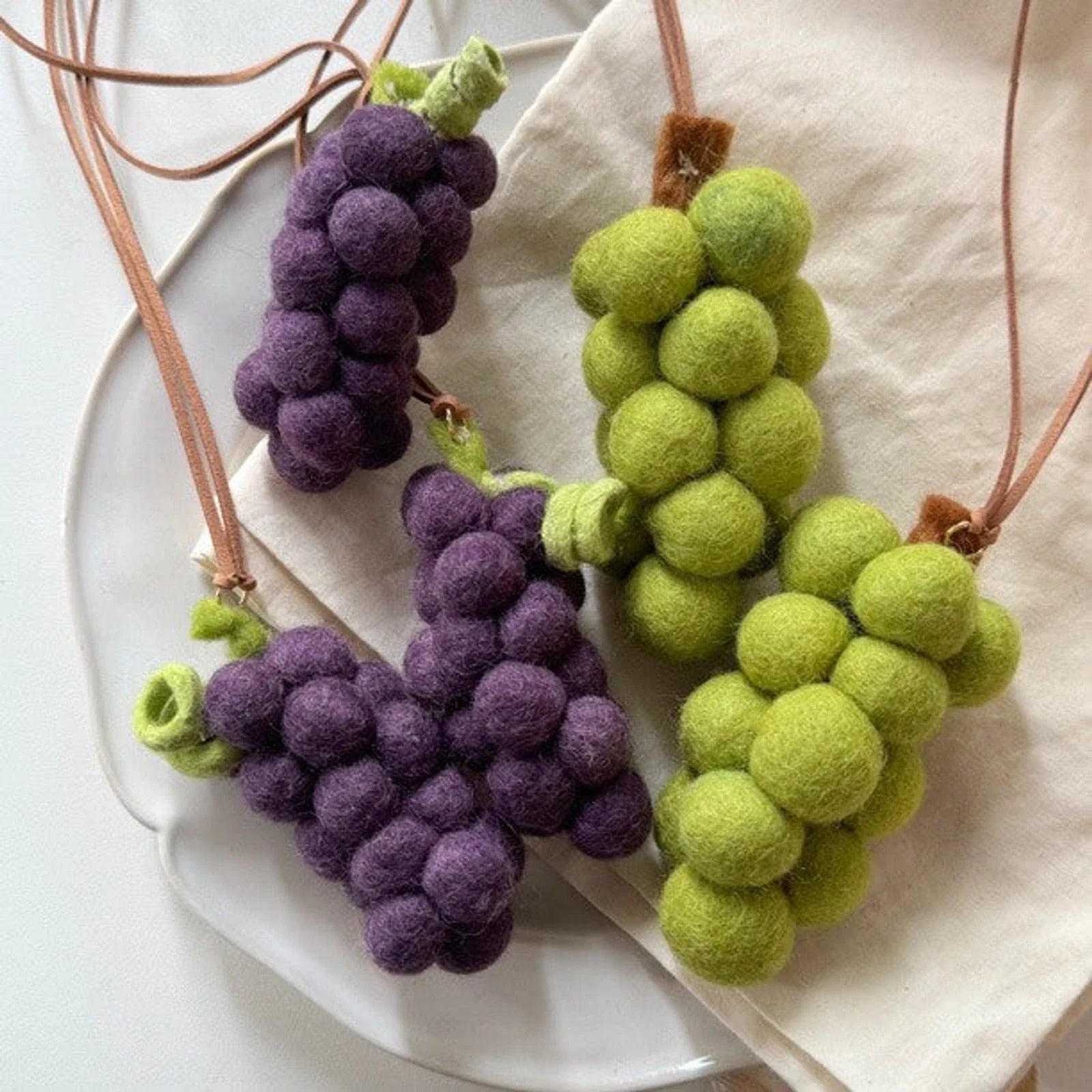 Wool felt grape charms styled on neutral linen