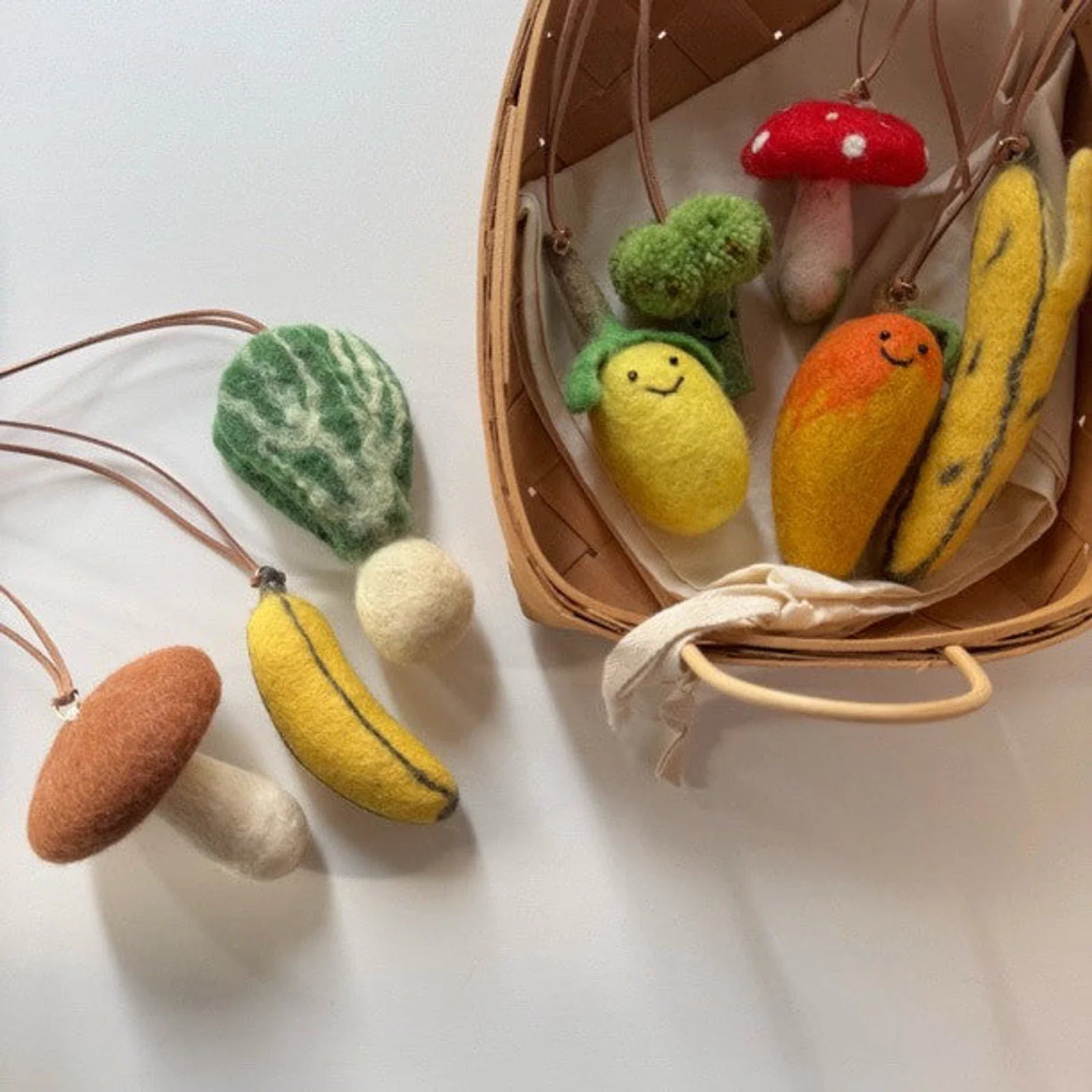 Wool felt banana and vegetable charms styled on a plate