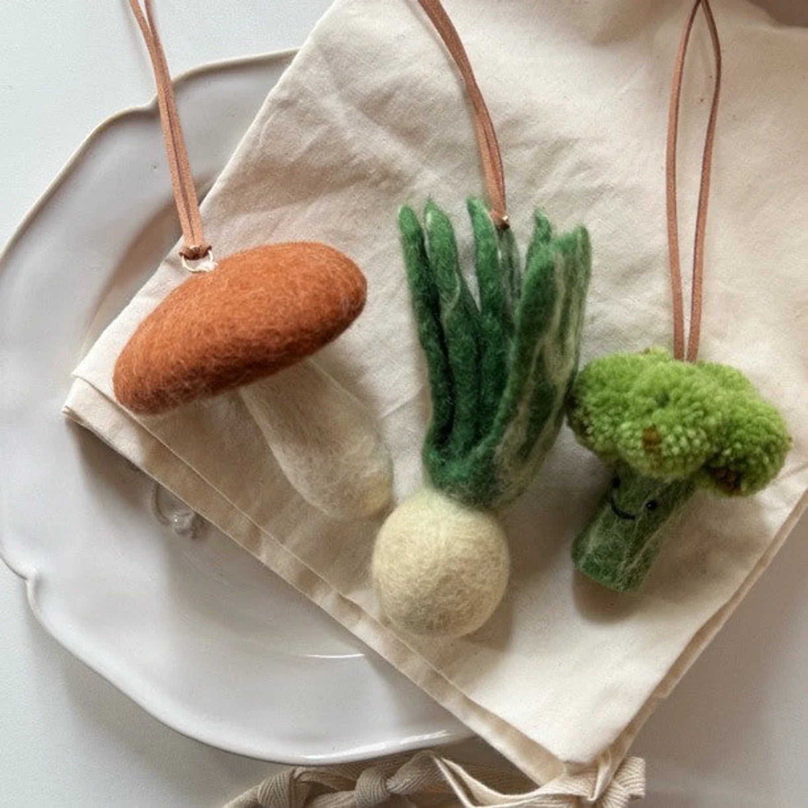 Wool felt vegetable hanging charms on neutral linen