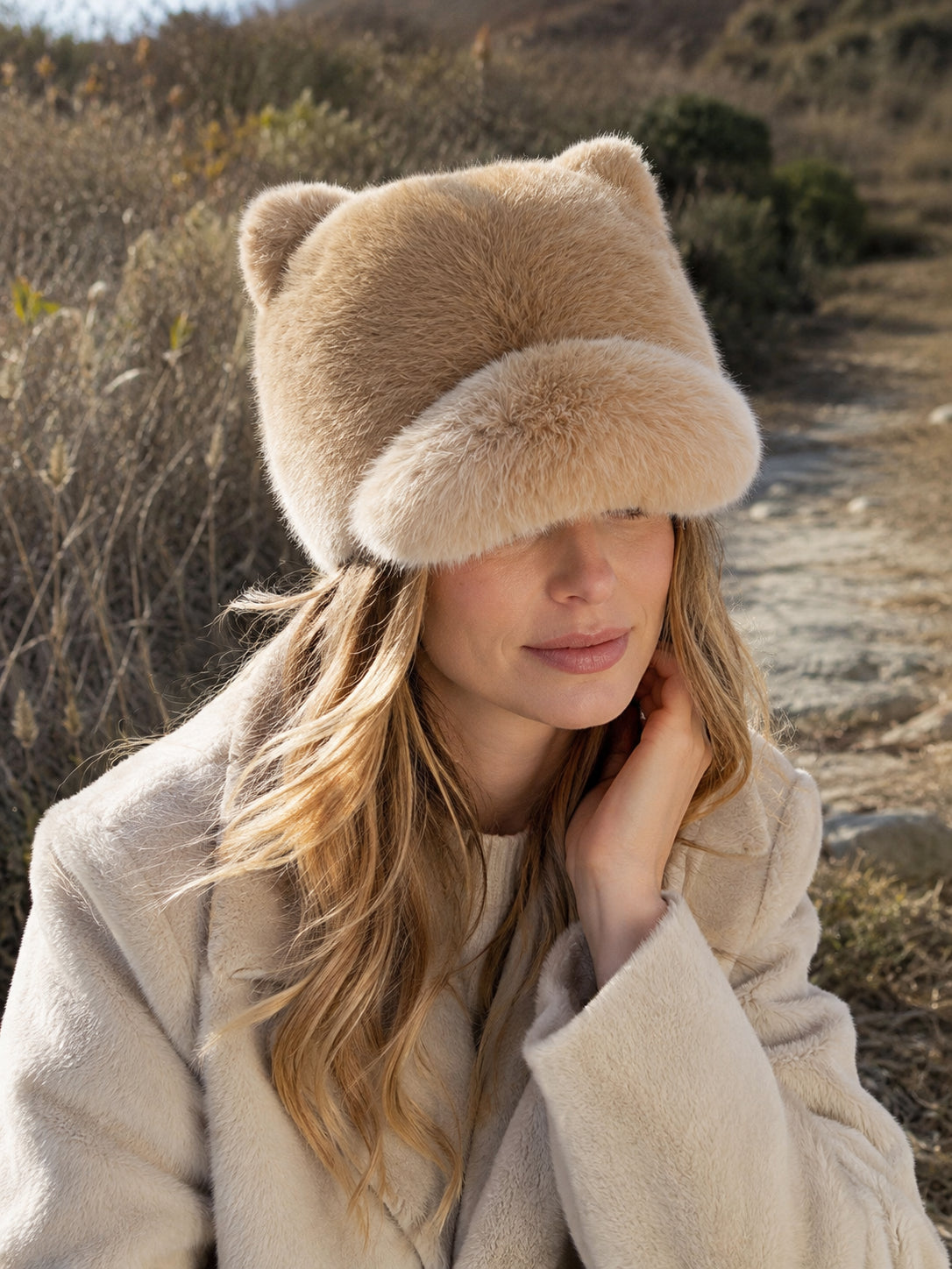 Woman styling a Sunset Yellow rabbit fur cat-ear winter cap outdoors