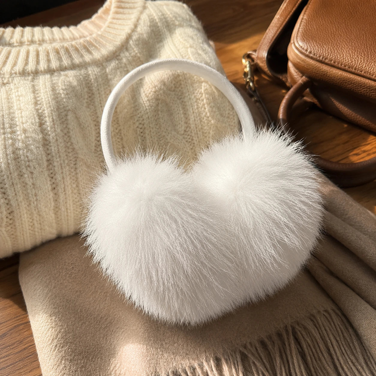 Arctic white genuine fox fur earmuffs styled with natural winter layers