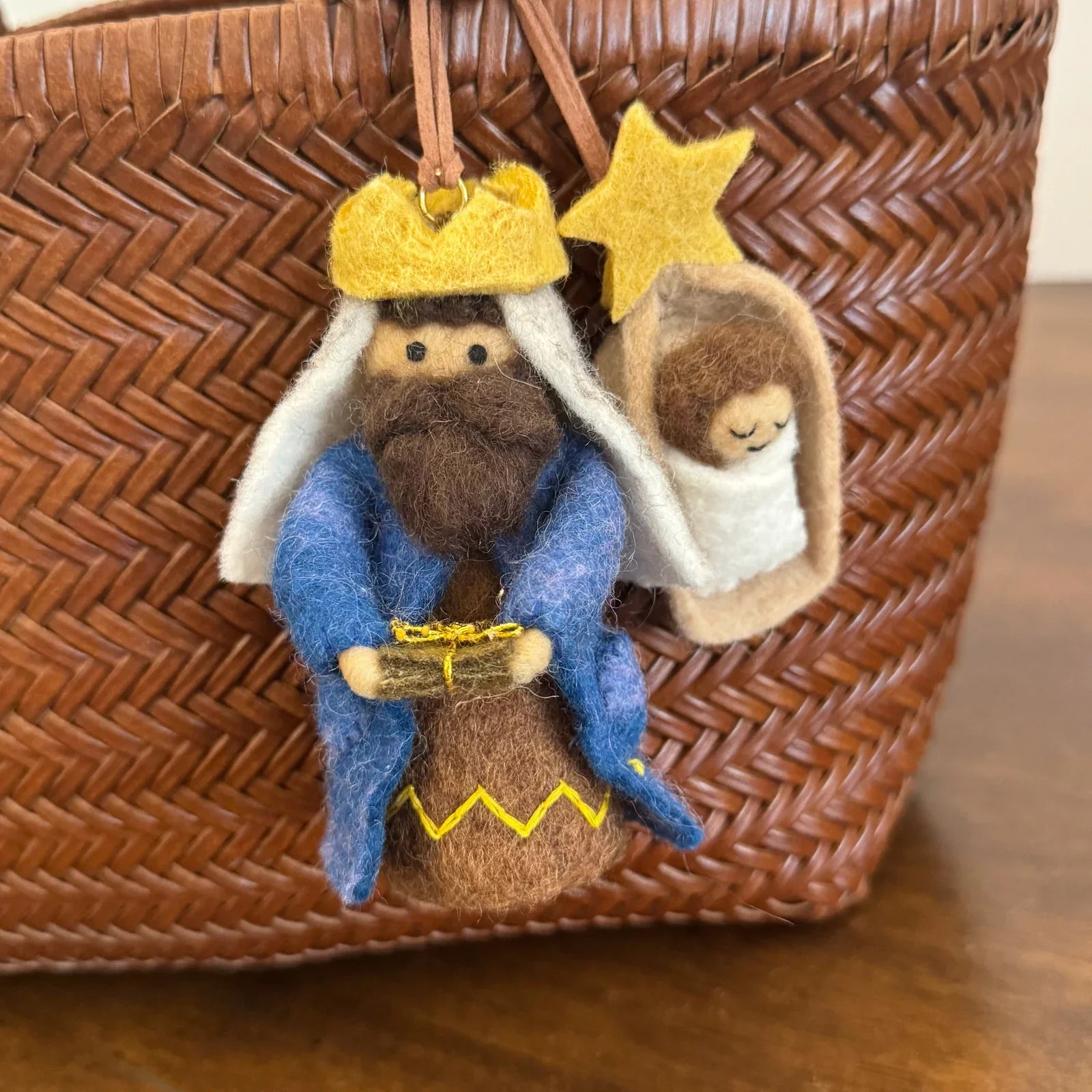 Detailed view of hand-shaped wool felt characters and decorative stitching