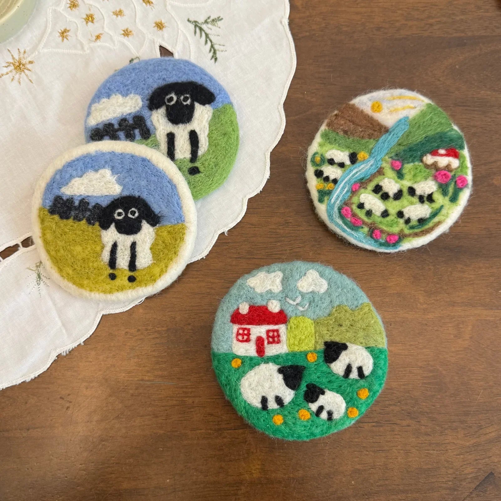 Handcrafted felt coasters with dimensional sheep and cottage scenes