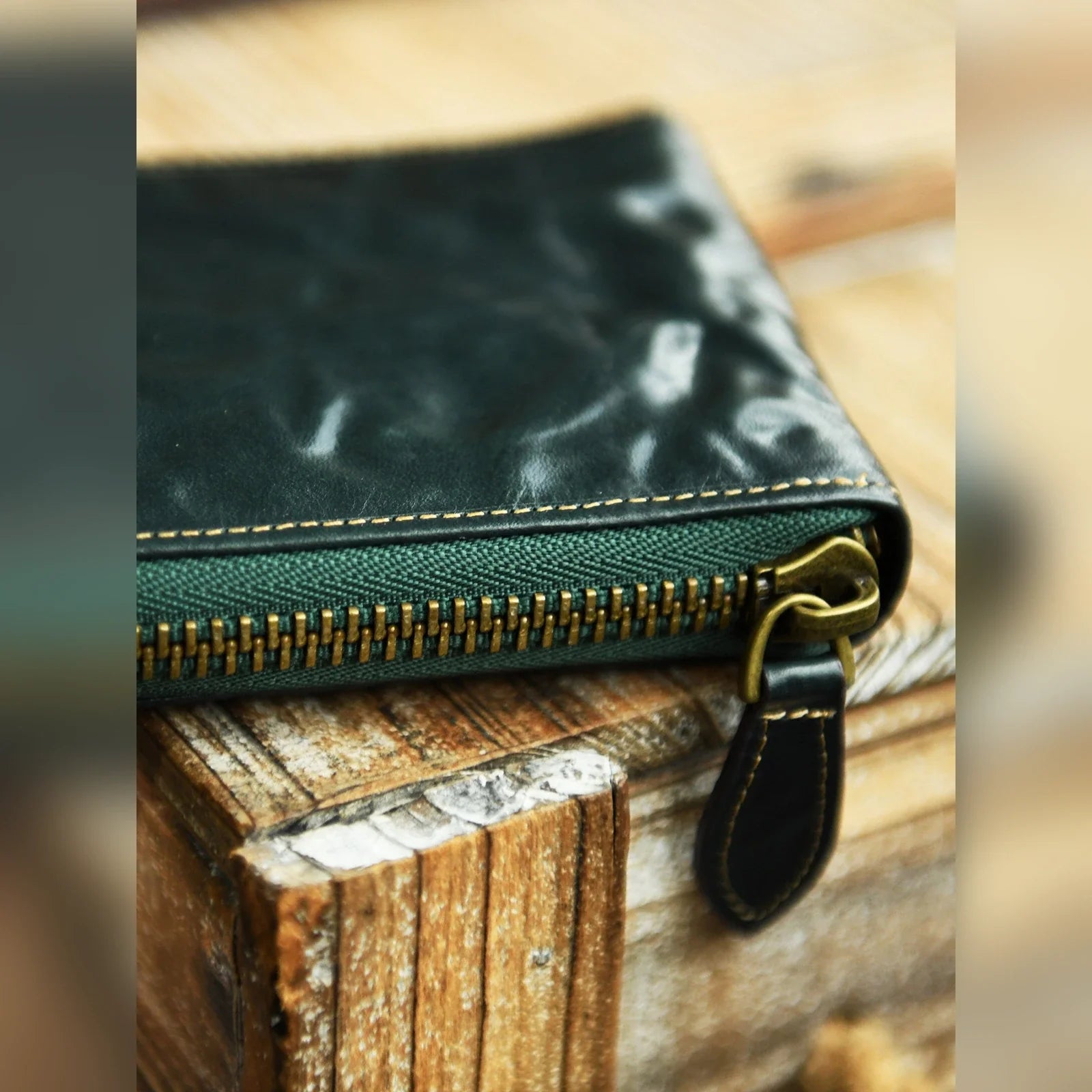 Close view of Forest Green cowhide leather, stitching and zipper hardware