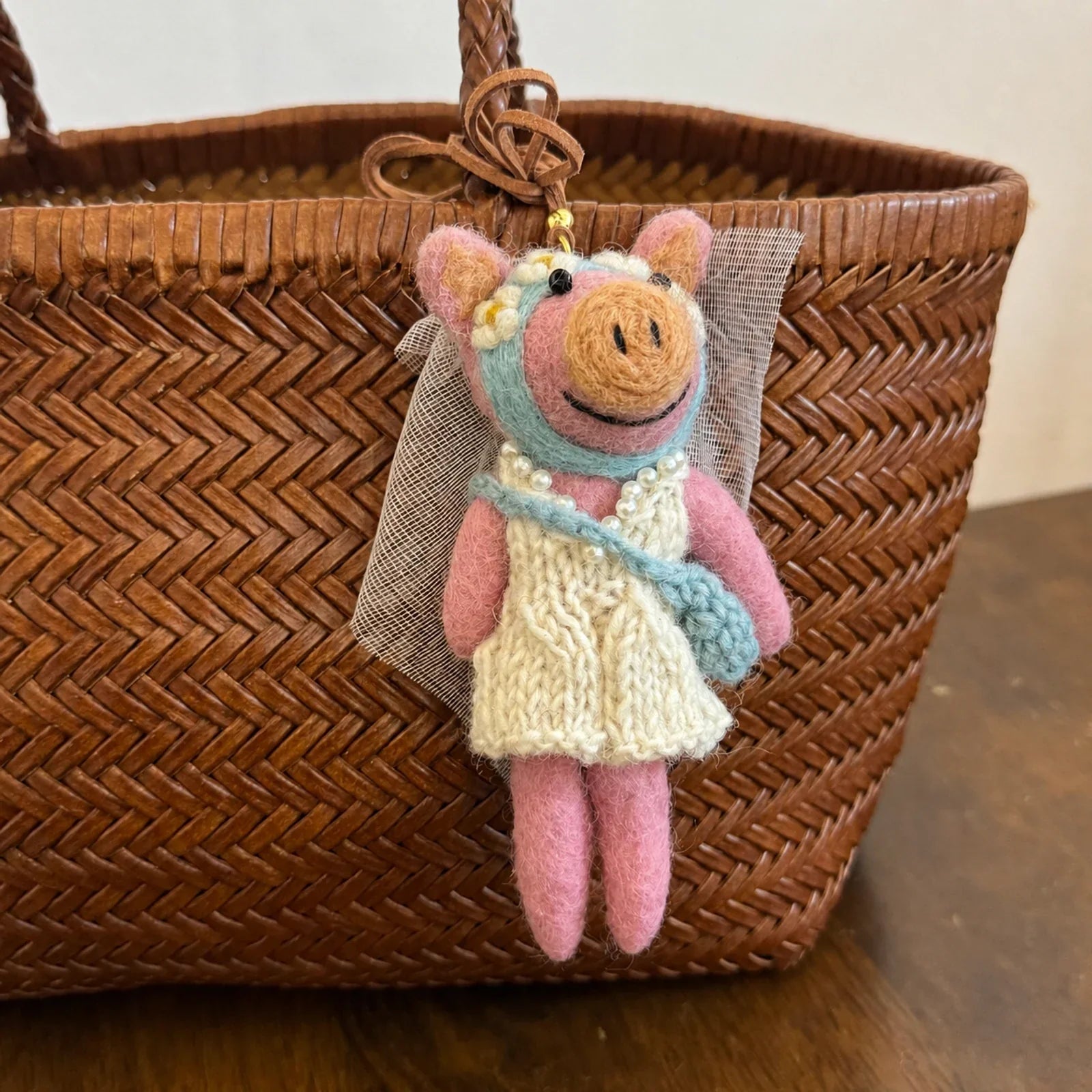 Handmade wool felt bridal pig charm on a woven bag