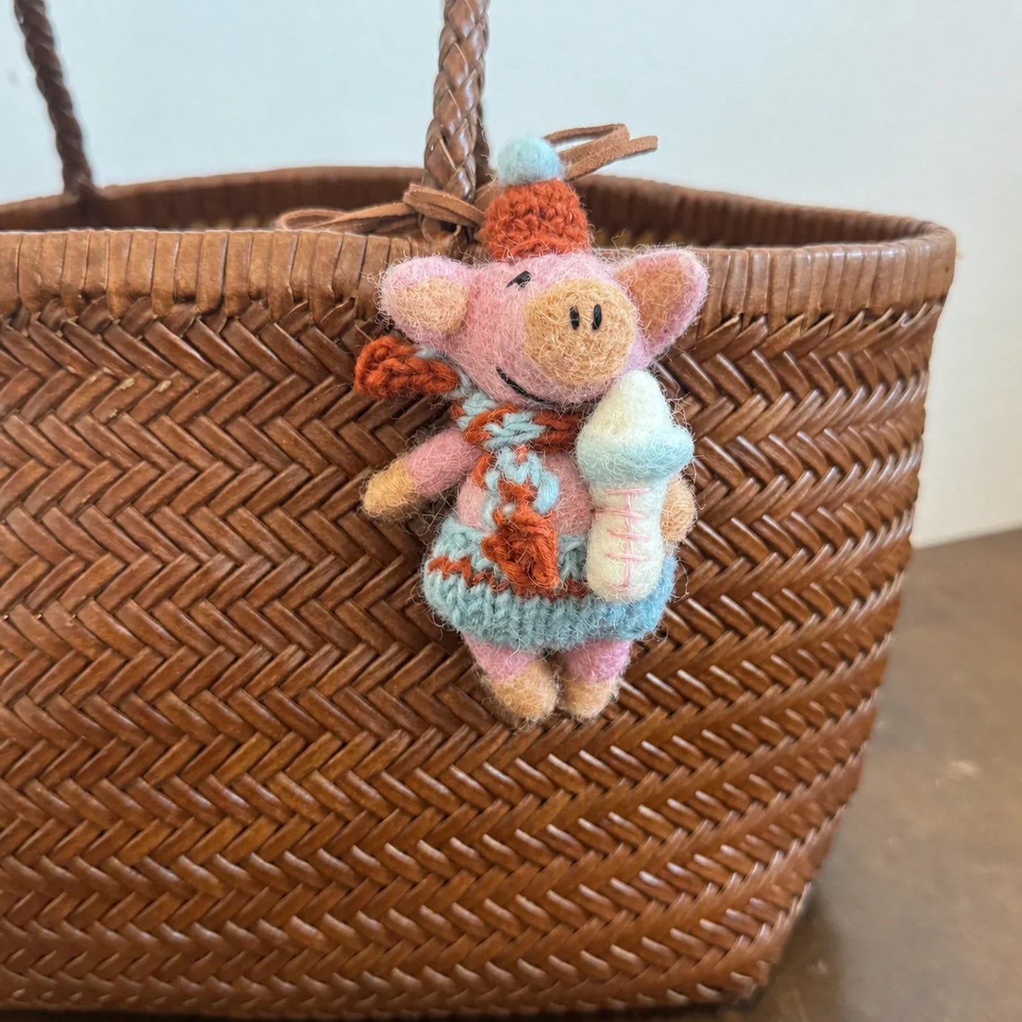 Handmade wool felt pig charm with a baby bottle detail
