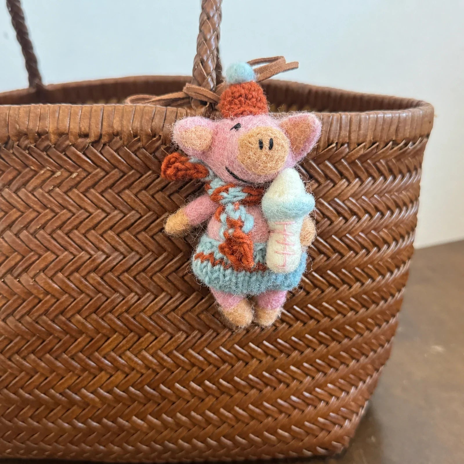 Handmade wool felt pig charm with a baby bottle detail
