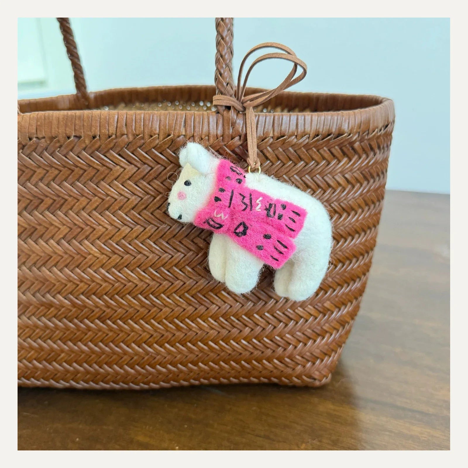 Handmade white wool felt bear bag charm with bright pink scarf and leather cord