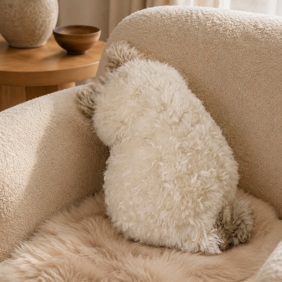 Milk coffee cat-shaped plush cushion on a boucle chair
