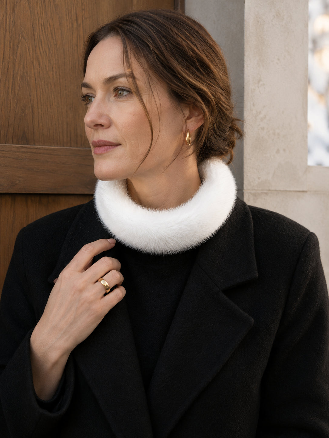 Woman styling an ivory mink fur circular collar scarf with a black coat