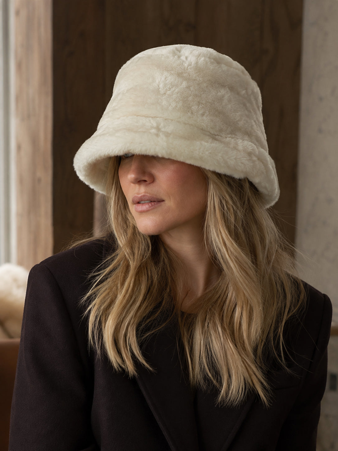 Person styling an Off-White genuine leather bucket hat indoors
