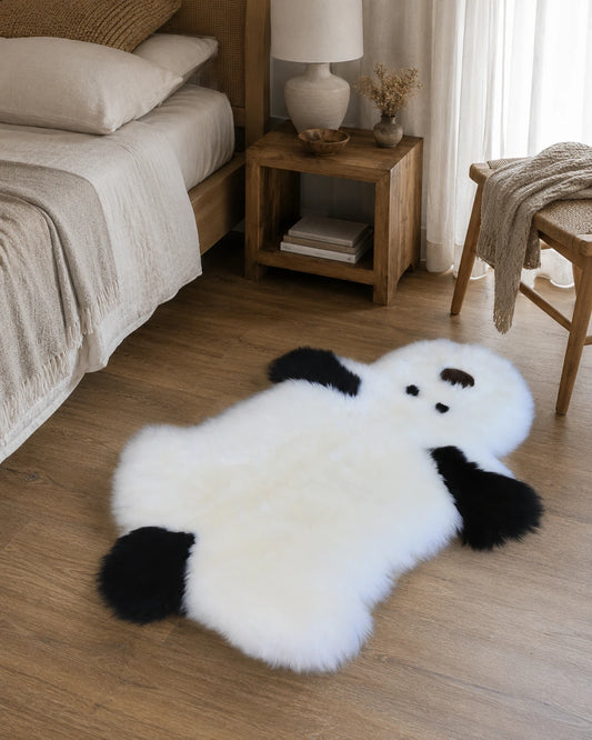 Capricornus Living Genuine sheepskin puppy-shaped rug placed beside a bed