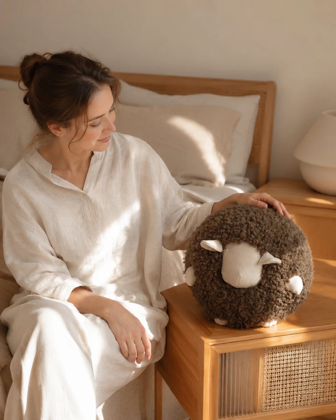 Capricornus Living Mocha Brown sheep pillow styled near a bedroom seat