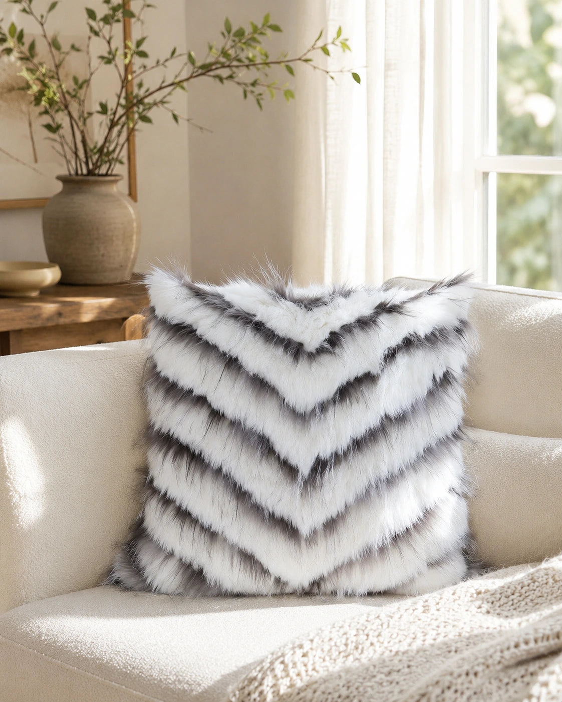 Capricornus Living Ivory White square genuine fur chevron pillow on a sunlit sofa