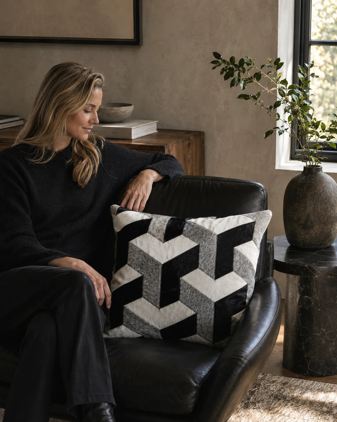 Capricornus Living Silver Gray geometric cowhide pillow used on a black leather chair