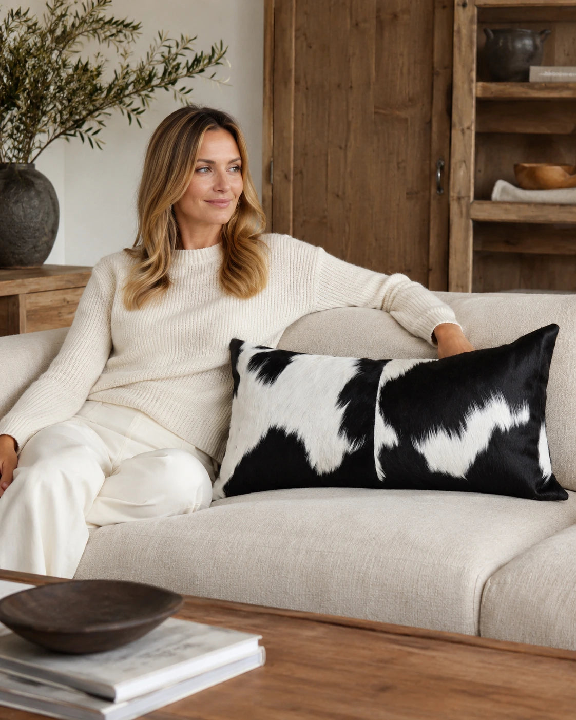 Capricornus Living Adult with a Black and White Spotted genuine cowhide lumbar pillow on a sofa