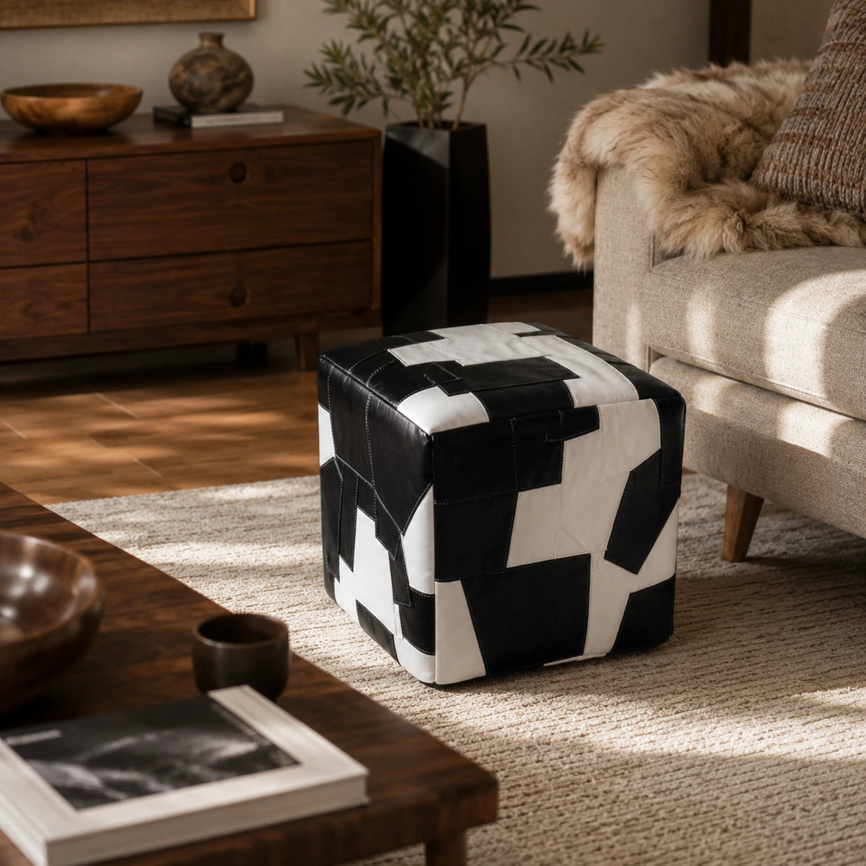 Black and ivory leather cube ottoman styled beside a neutral sofa