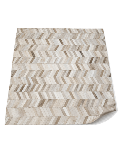 Capricornus Living Herringbone Beige genuine cowhide patchwork rug angled on a transparent background