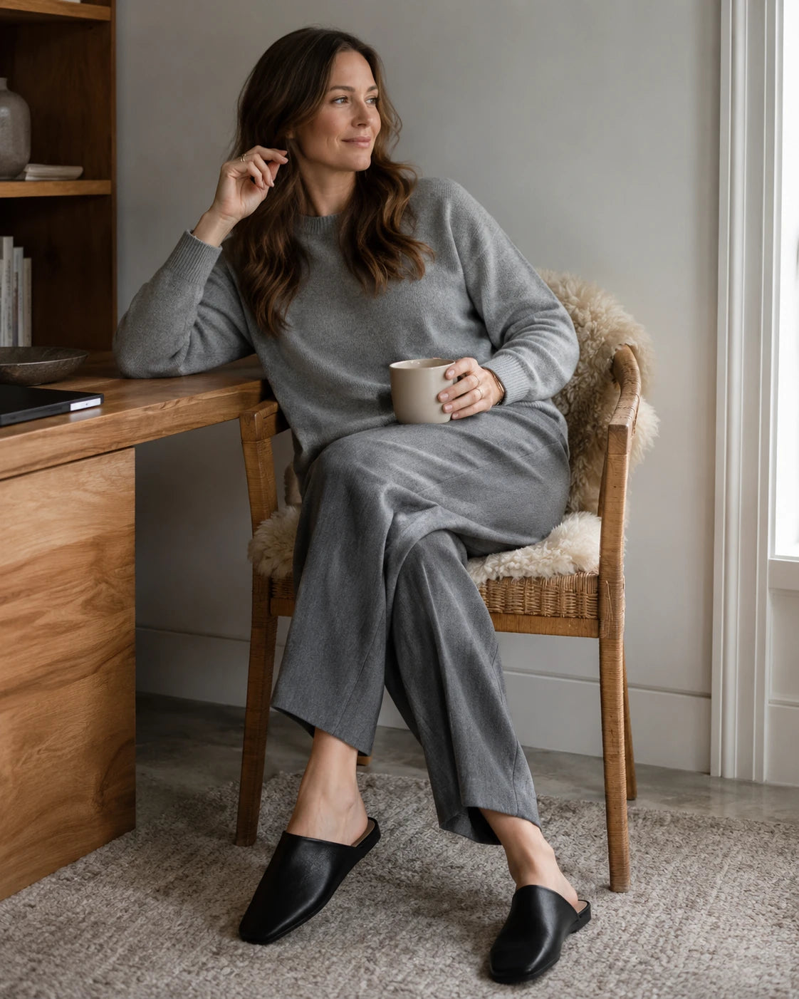 Capricornus Living Black leather house slippers worn at a home-office desk