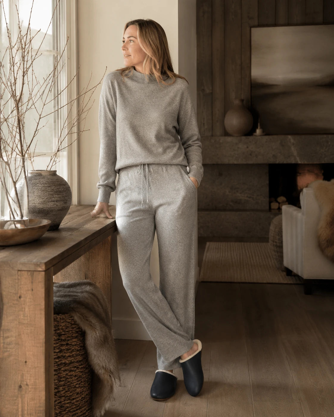 Capricornus Living Black lambskin plush-lined slippers worn in a quiet home interior