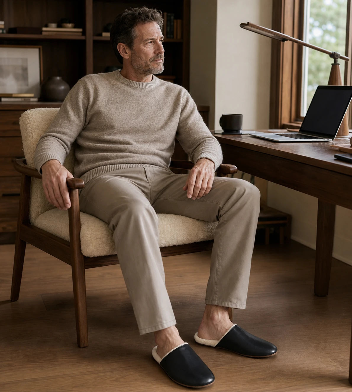 Capricornus Living Black lambskin plush-lined slippers worn by a man in a home office