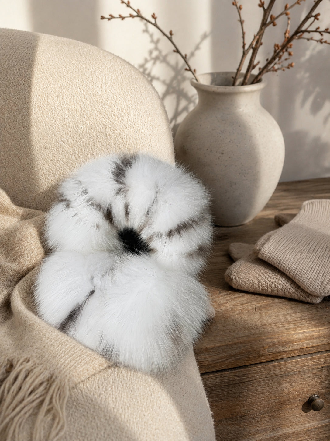 White Leopard fox fur earmuffs in a warm interior still life