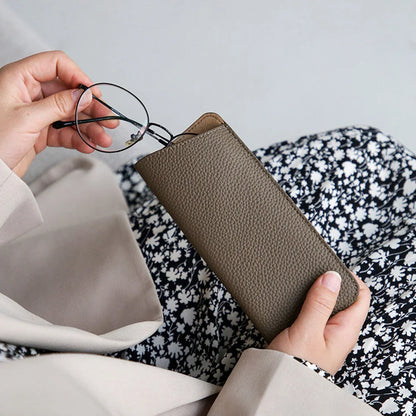 Eyeglasses being placed into a pebbled cowhide sleeve