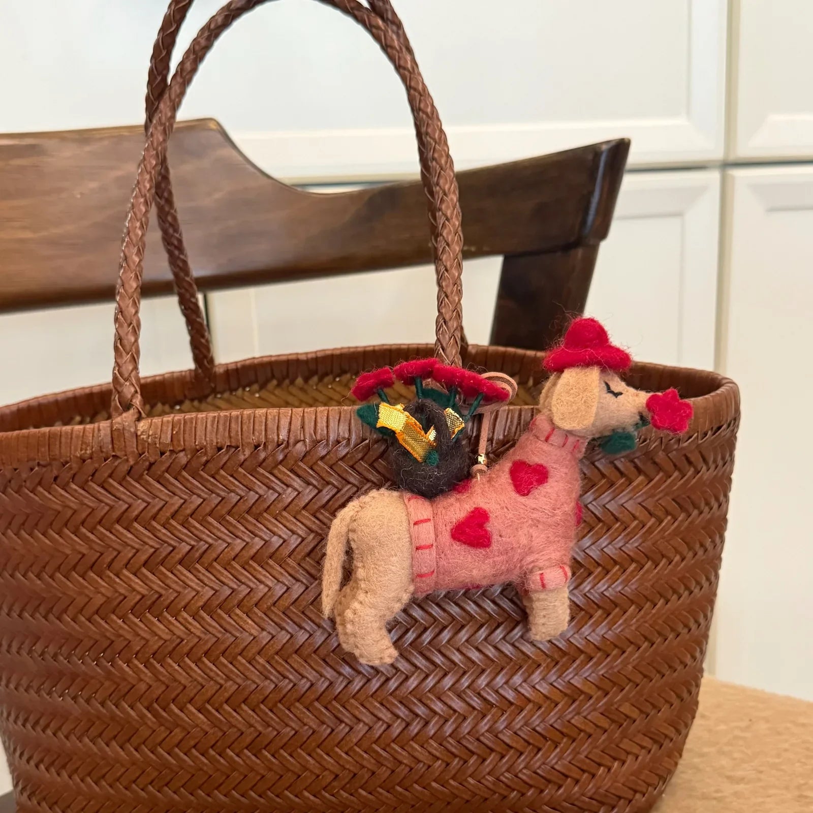 Rose dog wool felt bag charm styled on a woven tote