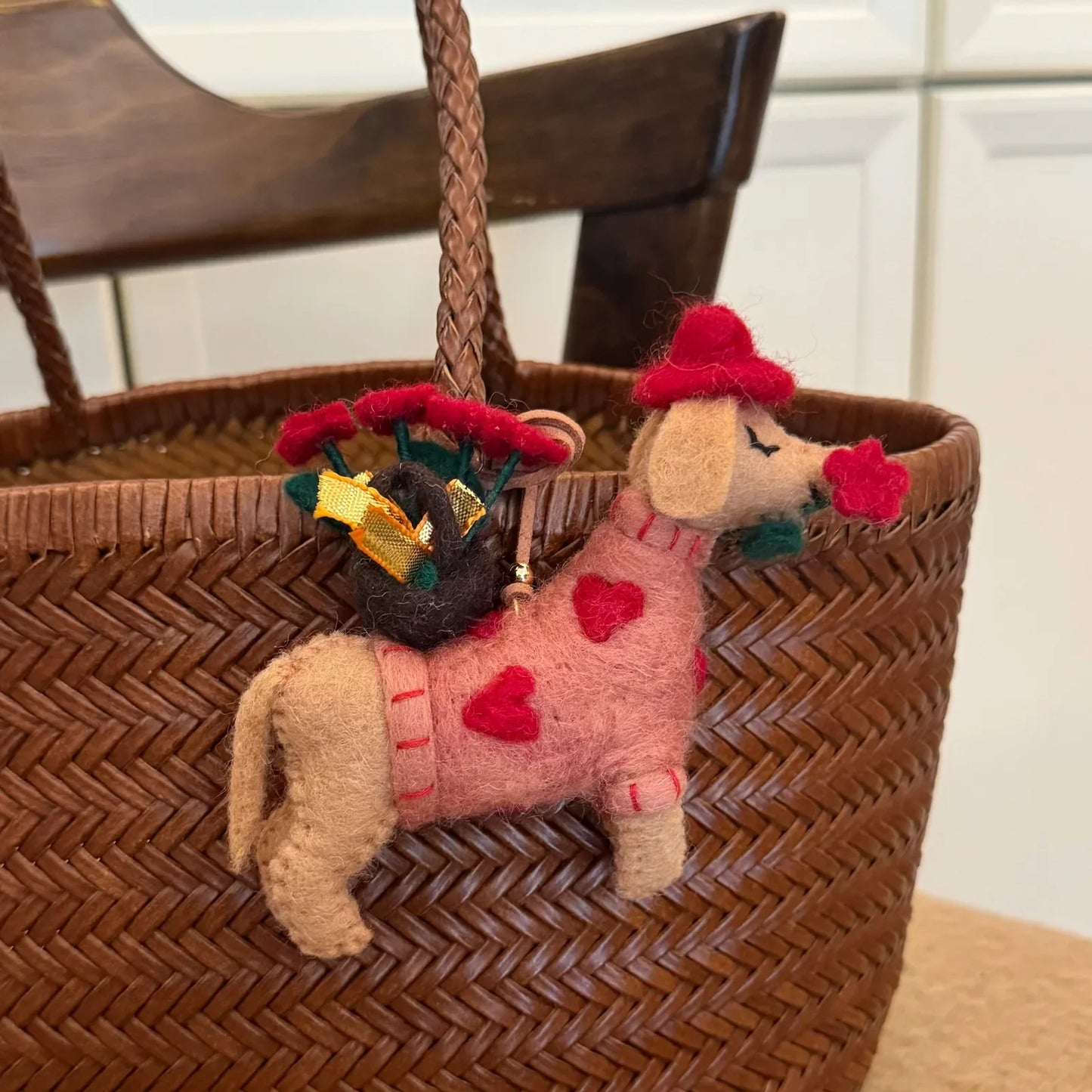 Rose dog wool felt charm attached to a woven bag