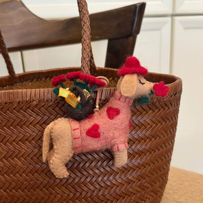 Rose dog wool felt charm attached to a woven bag