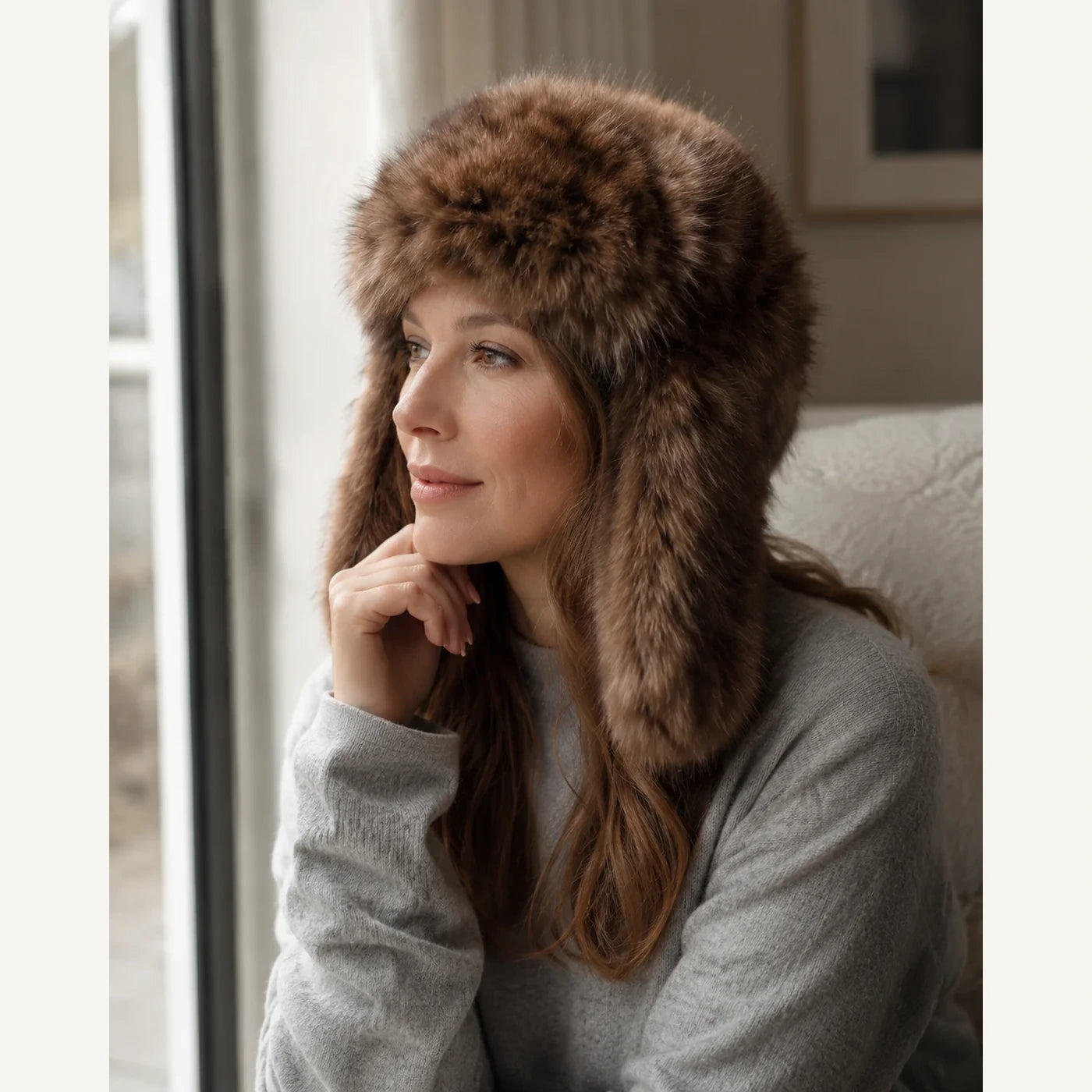Deep Sable Brown genuine sable fur trapper hat worn near winter window