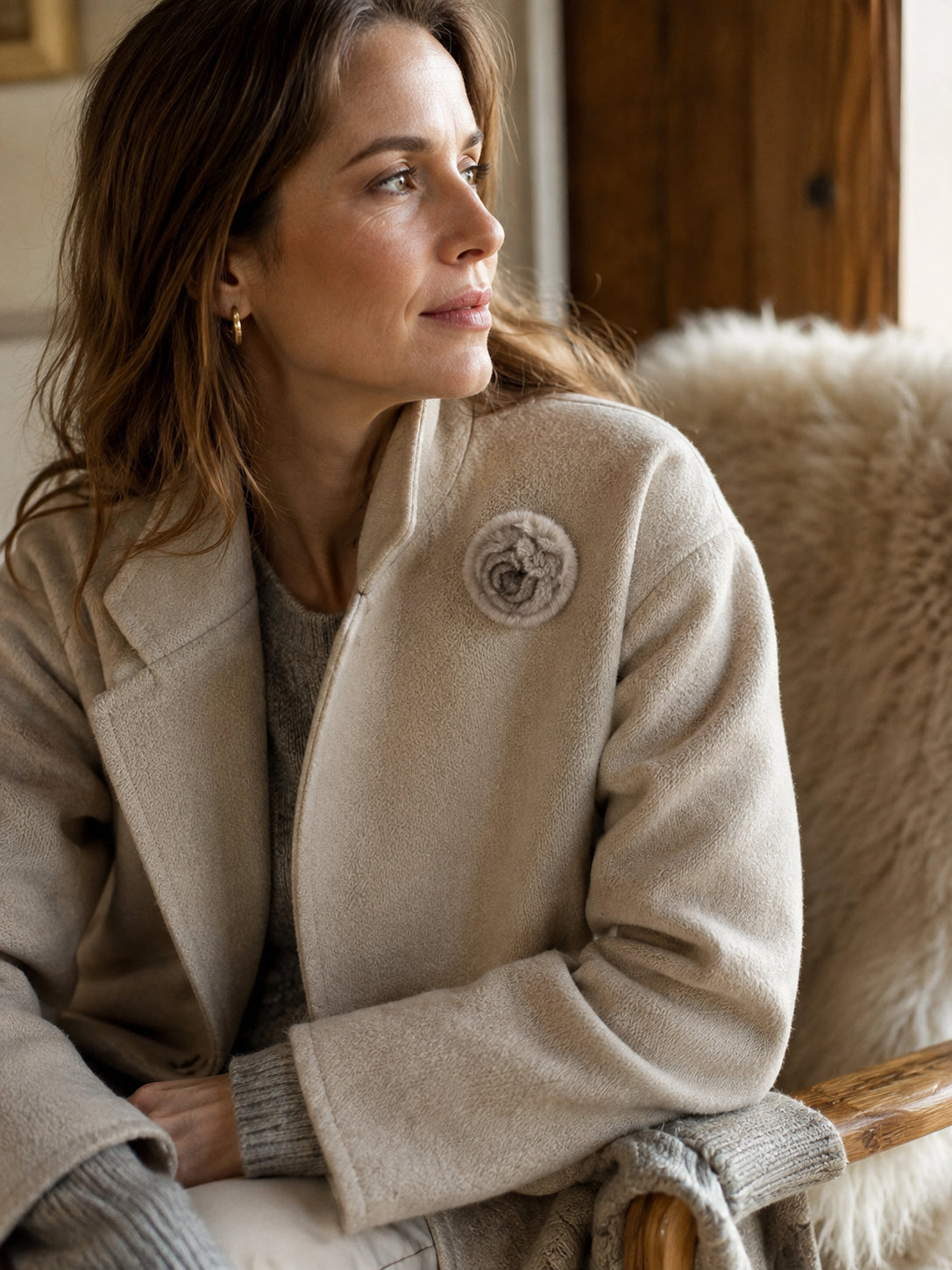 Silver Blue camellia flower brooch styled on a tailored coat indoors