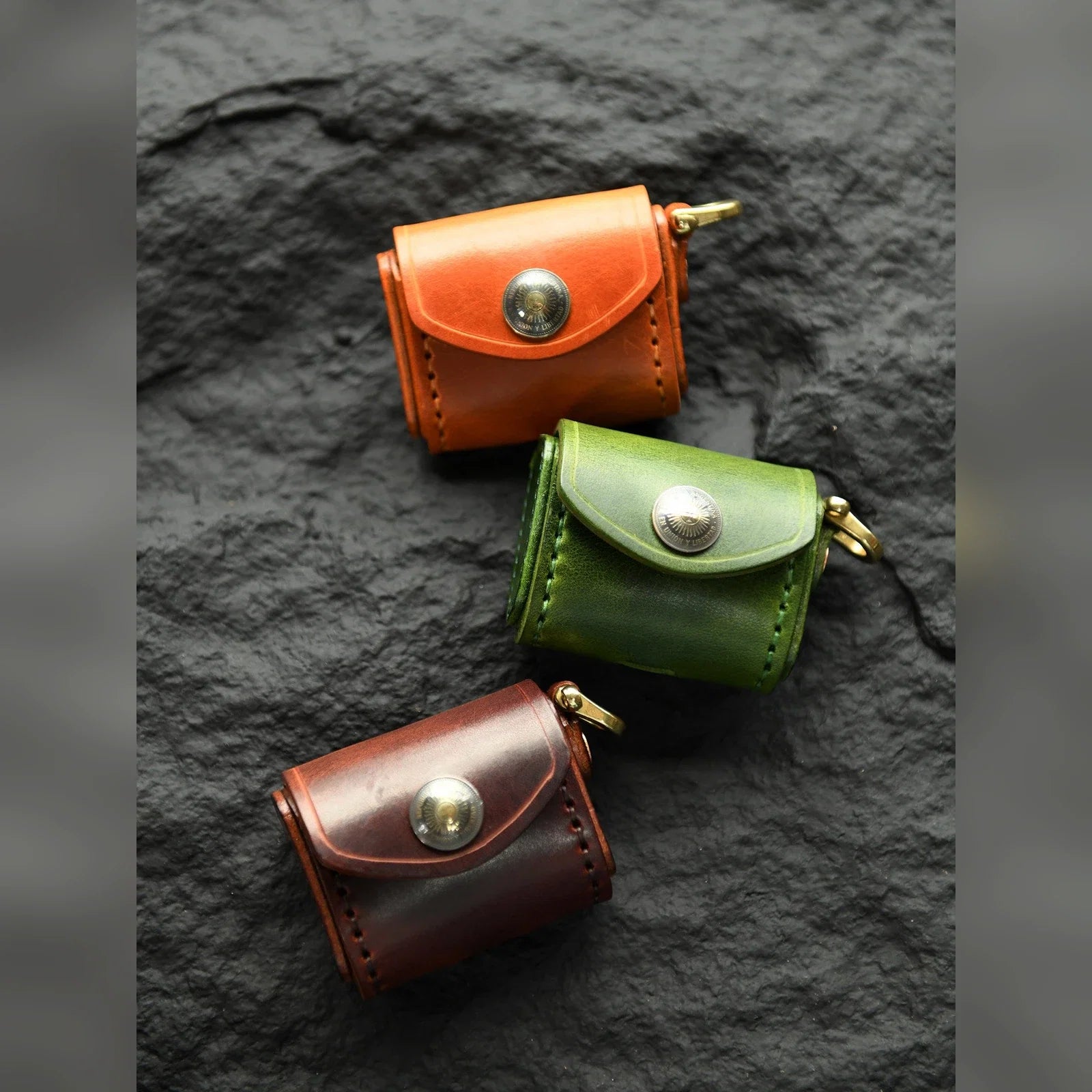 Top-grain cowhide earbud cases in Sunset Tan, Forest Green and Deep Brown
