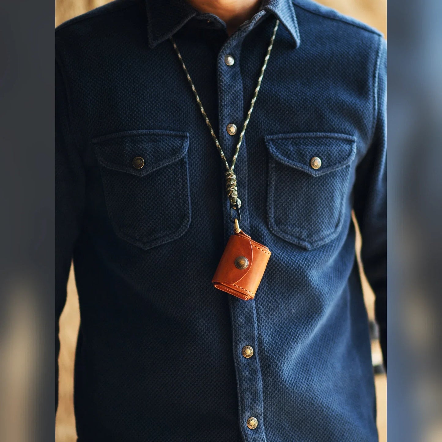 Sunset Tan leather earbud case worn with a neck cord