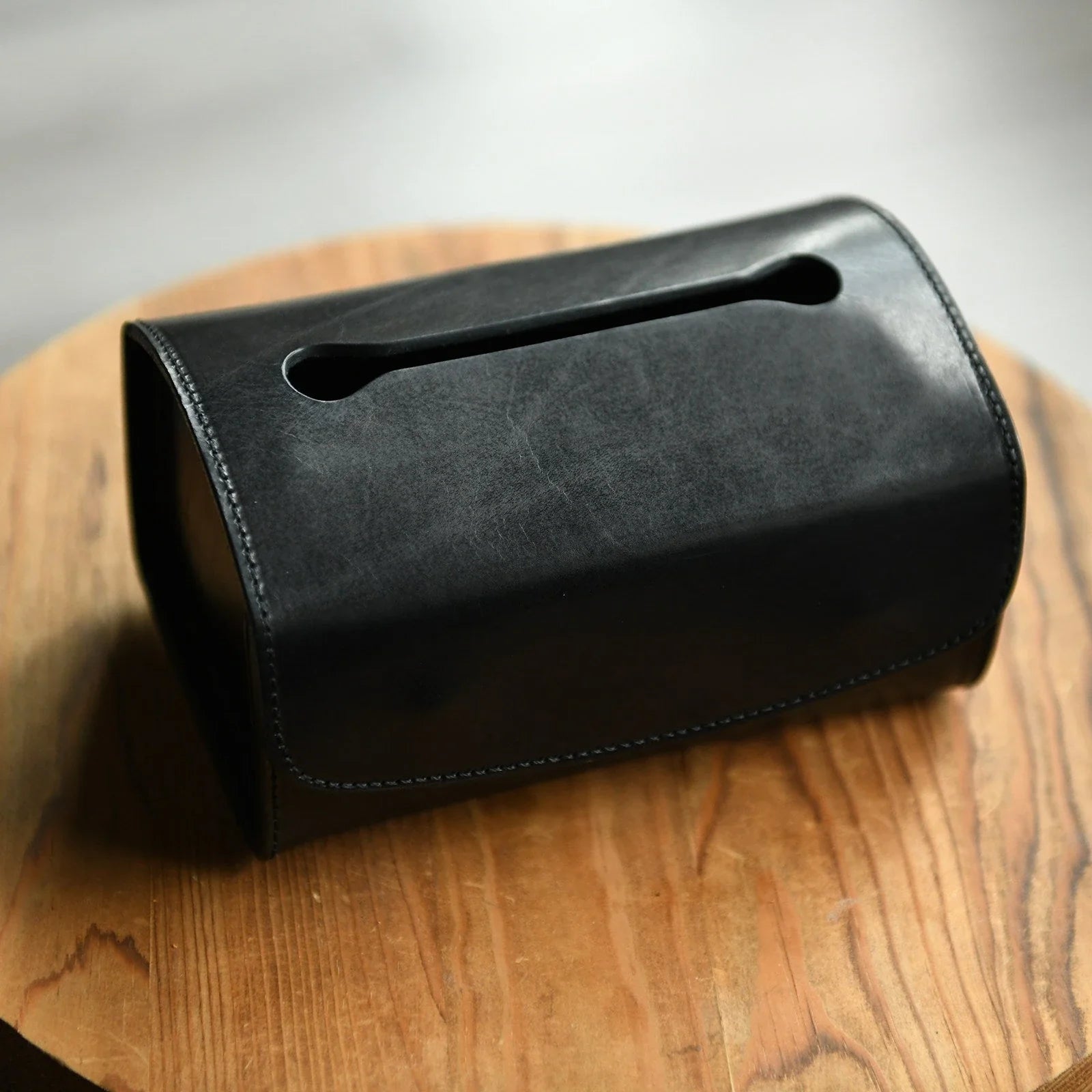 Black top-grain cowhide tissue box cover showing natural grain and stitching