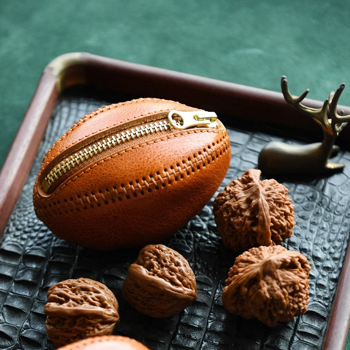 Hand-stitched leather rugby pouch in a styled tabletop setting