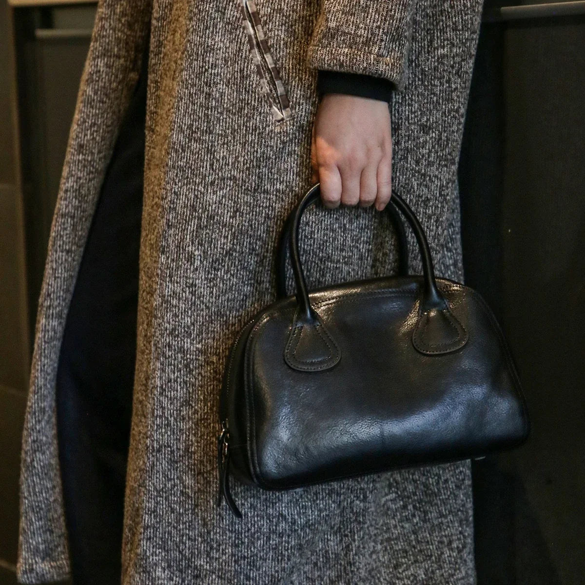 Black vegetable-tanned cowhide bowling bag carried by top handles