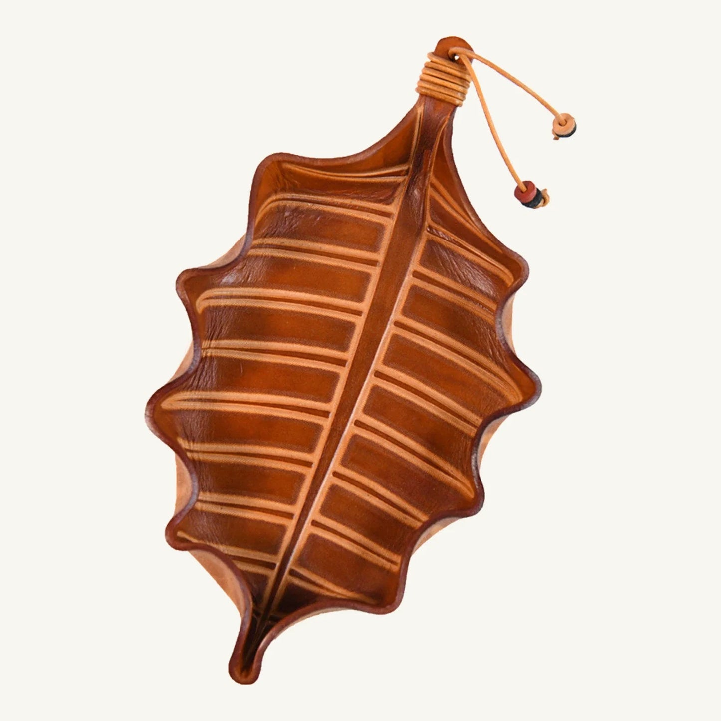 Leaf-shaped vegetable-tanned cowhide valet tray on a clean background