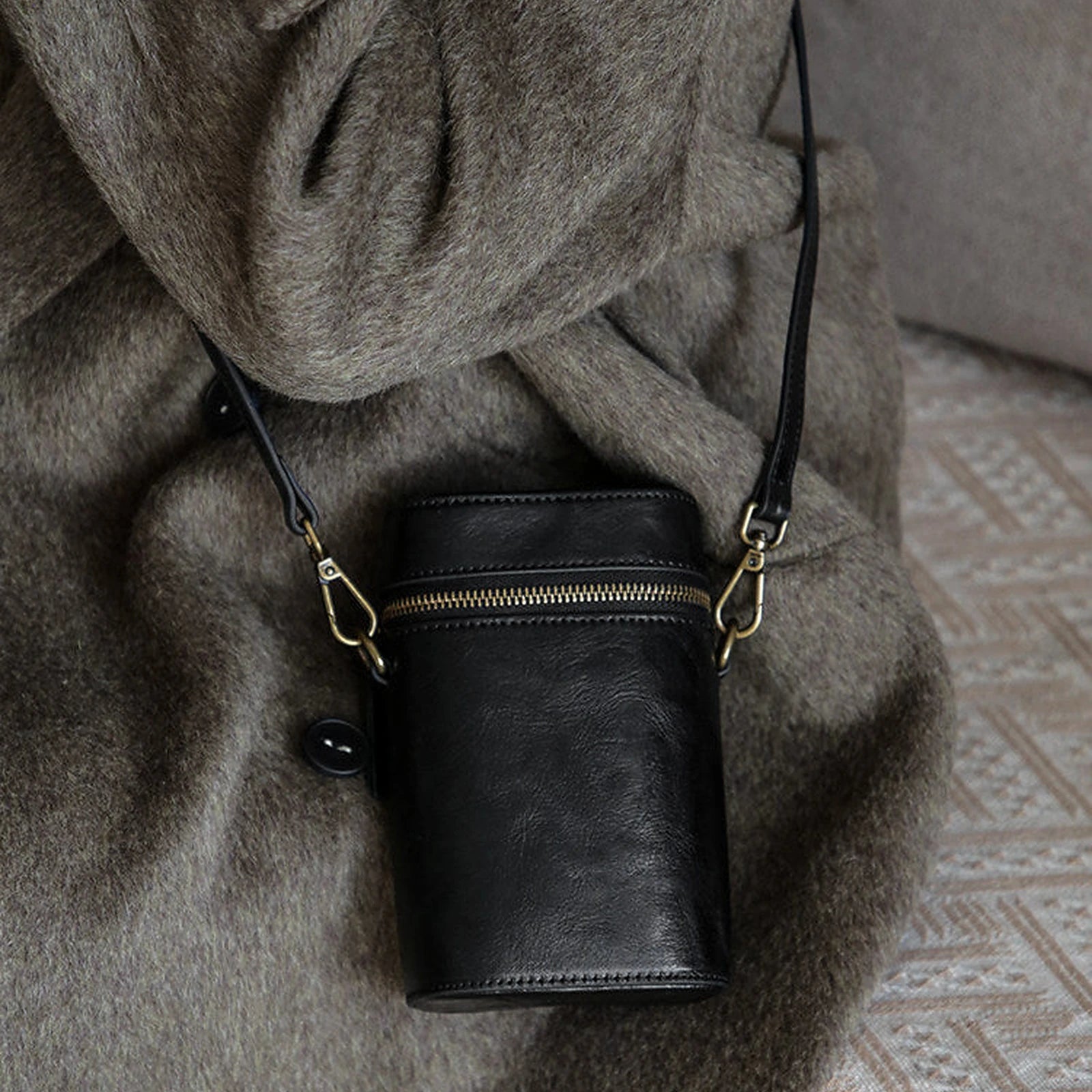 Close styling view of the Black vegetable-tanned cowhide phone crossbody bag