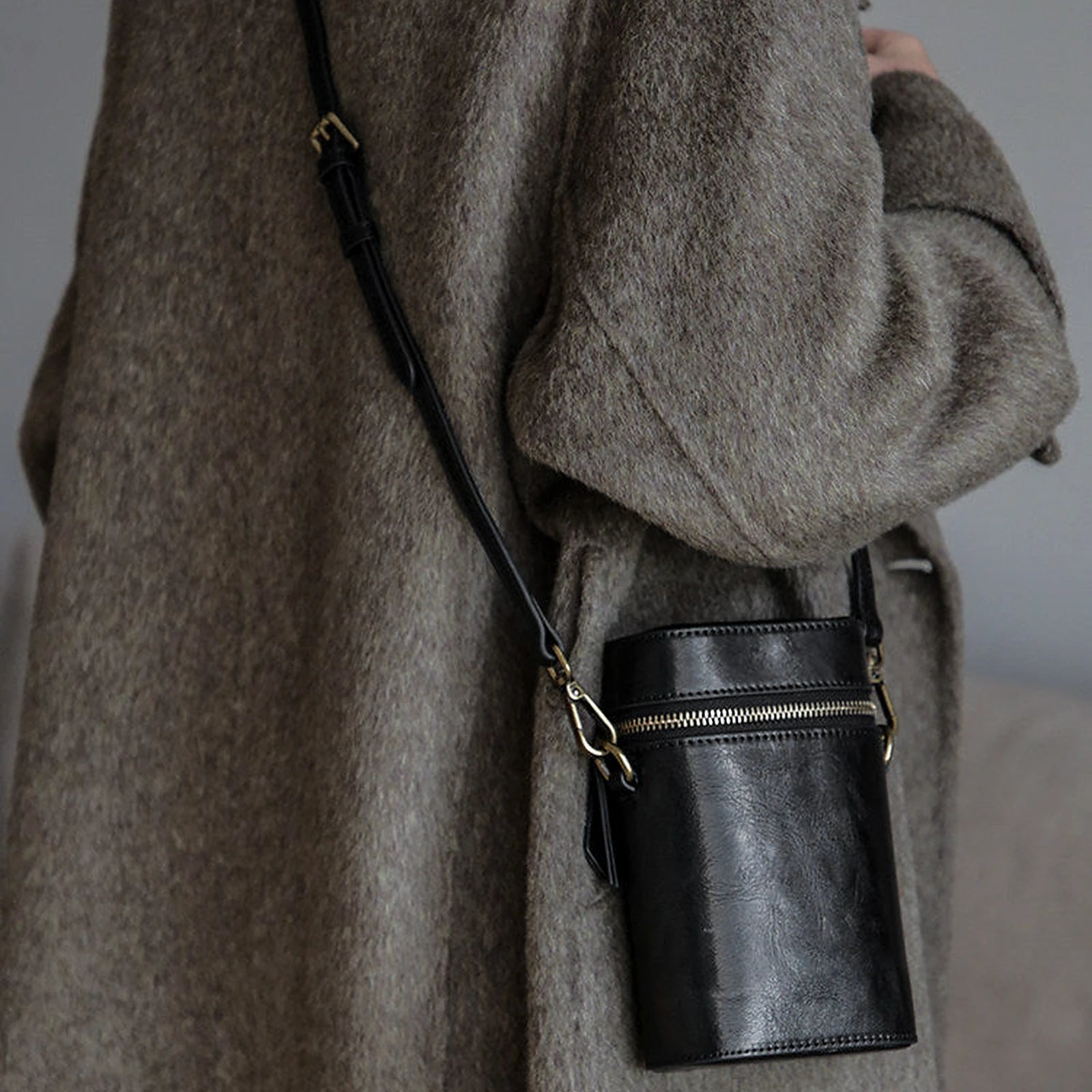 Black vegetable-tanned cowhide phone crossbody bag in a full styling view