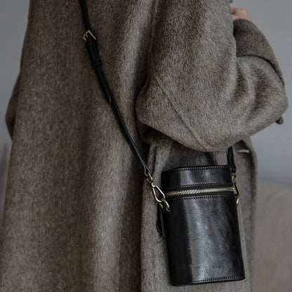 Black vegetable-tanned cowhide phone crossbody bag in a full styling view