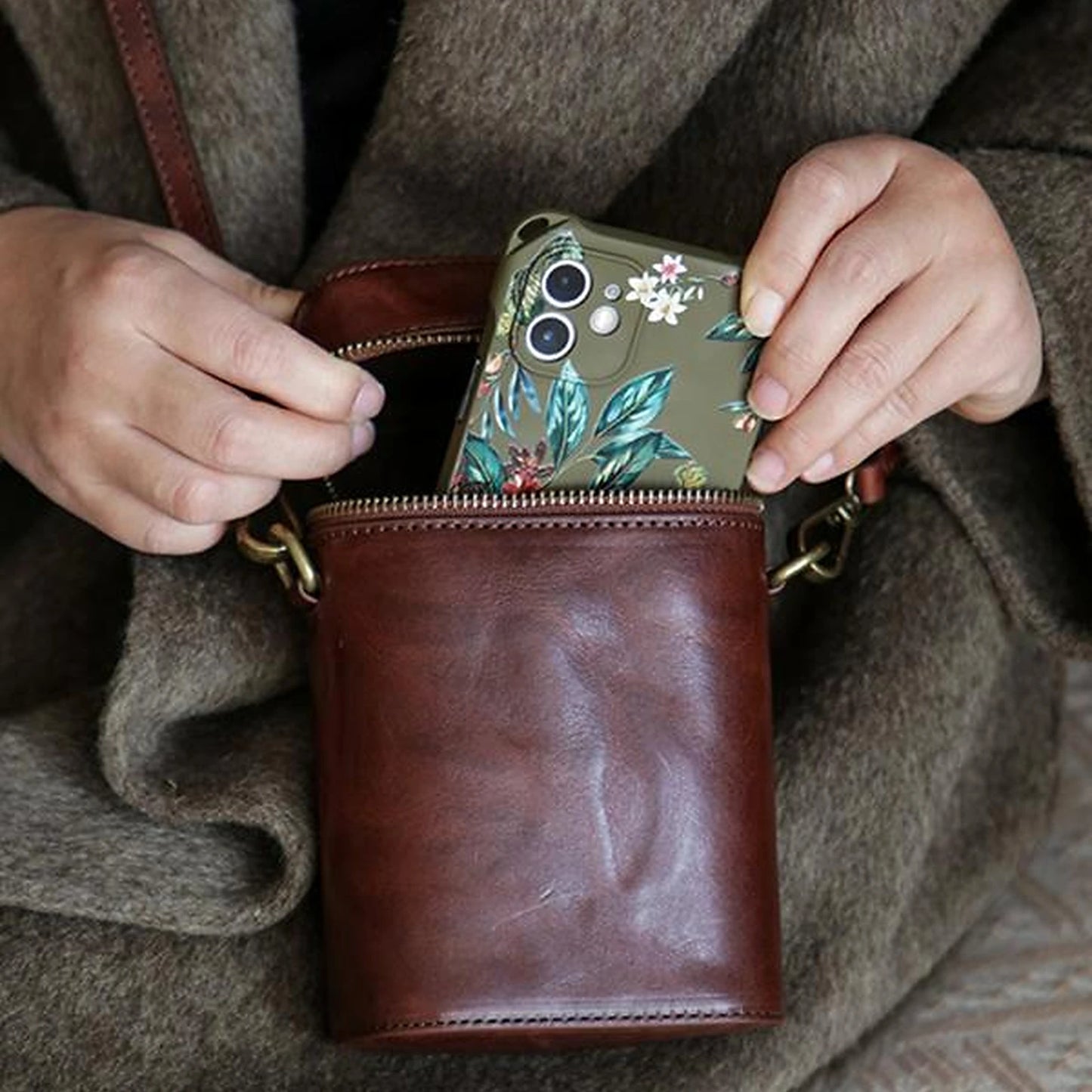 Vegetable-tanned cowhide phone crossbody bag shown holding a smartphone