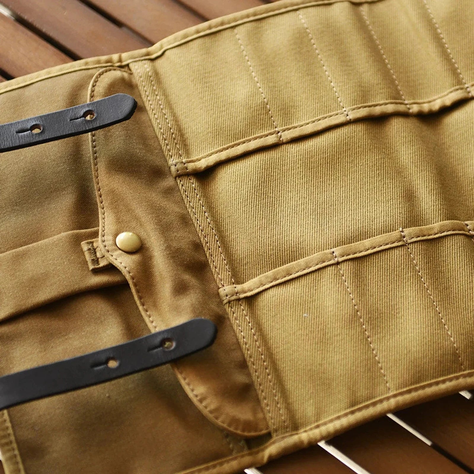 Close view of waxed canvas stitching, pockets and cowhide strap details