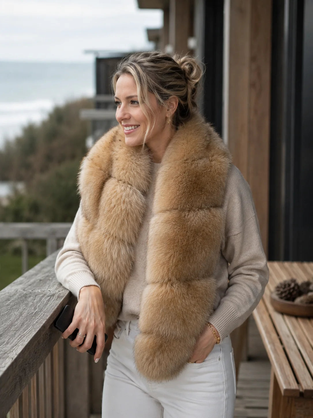 Woman wearing a golden brown blue fox fur scarf on a coastal terrace